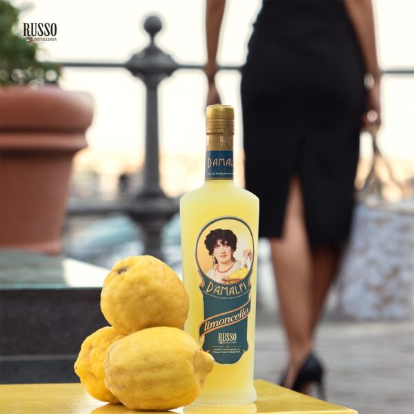 Donna sorridente con una bottiglia di Limoncello d’Amalfi IGP Distillatori Russo, mentre passeggia per le pittoresche vie della Costiera Amalfitana.